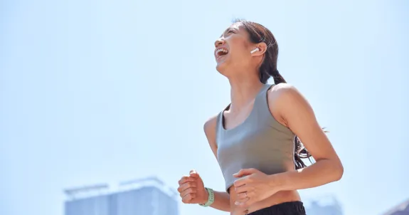 ランニングイヤホンをつけてランニングしている女