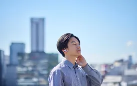 ハンズフリーイヤホンをつけて通話している男