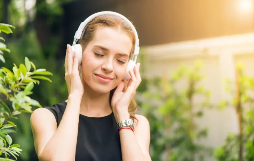 A girl is listening to music with a pair of headphones on