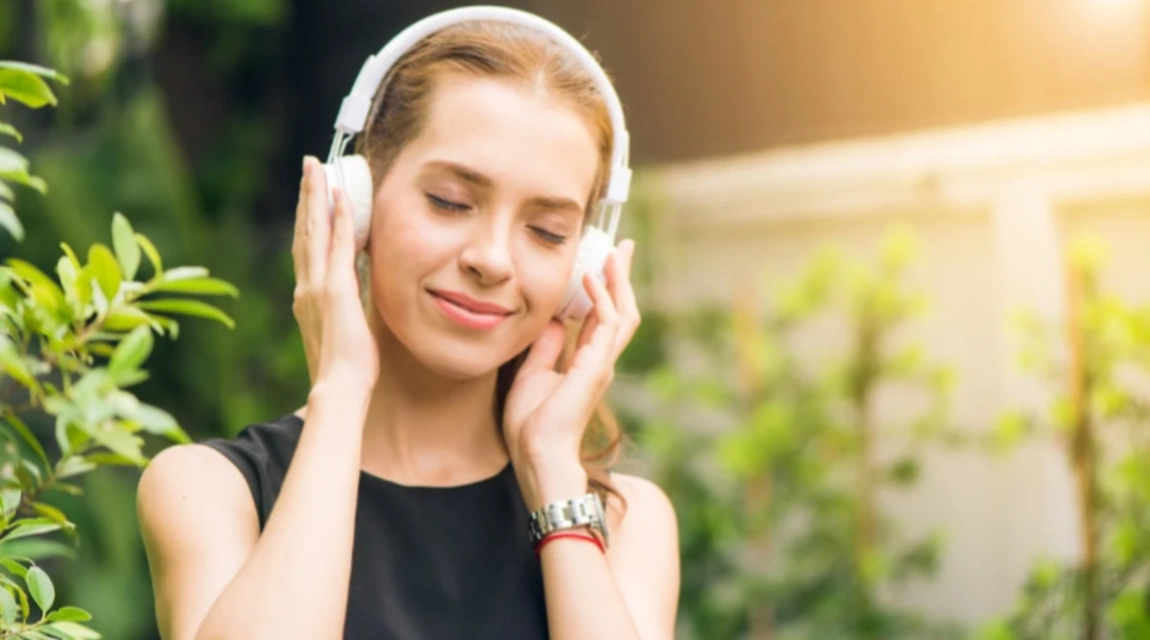 A girl is listening to music with a pair of headphones on