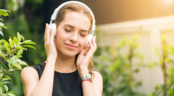 A girl is listening to music with a pair of headphones on