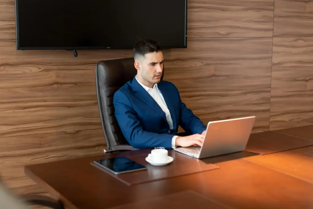 Ein Chef arbeitet mit einem Smartboard hinter sich.jpg