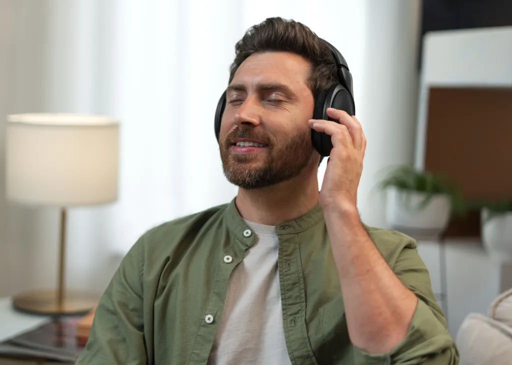 Man enjoying audio with lightweight headsets while relaxing at home