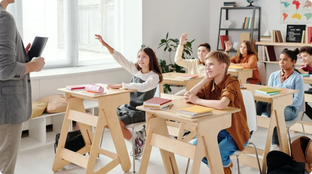 students raise their hands to answer questions in class