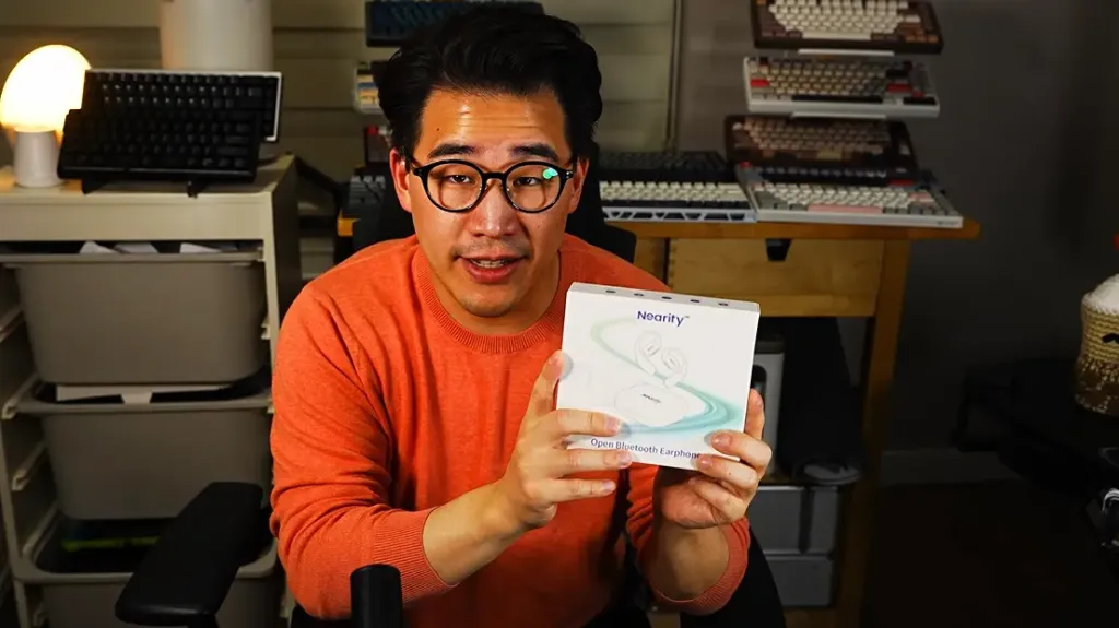 Mikey holding the Mempod Fit 2 earbuds