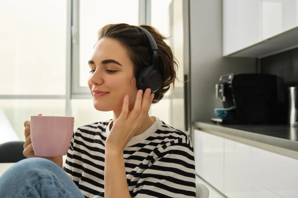Smiling woman enjoying music with ergonomic headsets