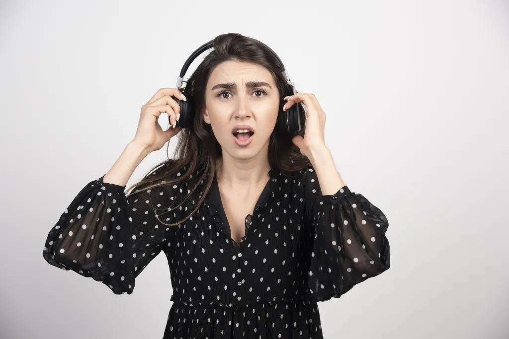 Startled young woman caught off guard by someone approaching while wearing isolating headphone