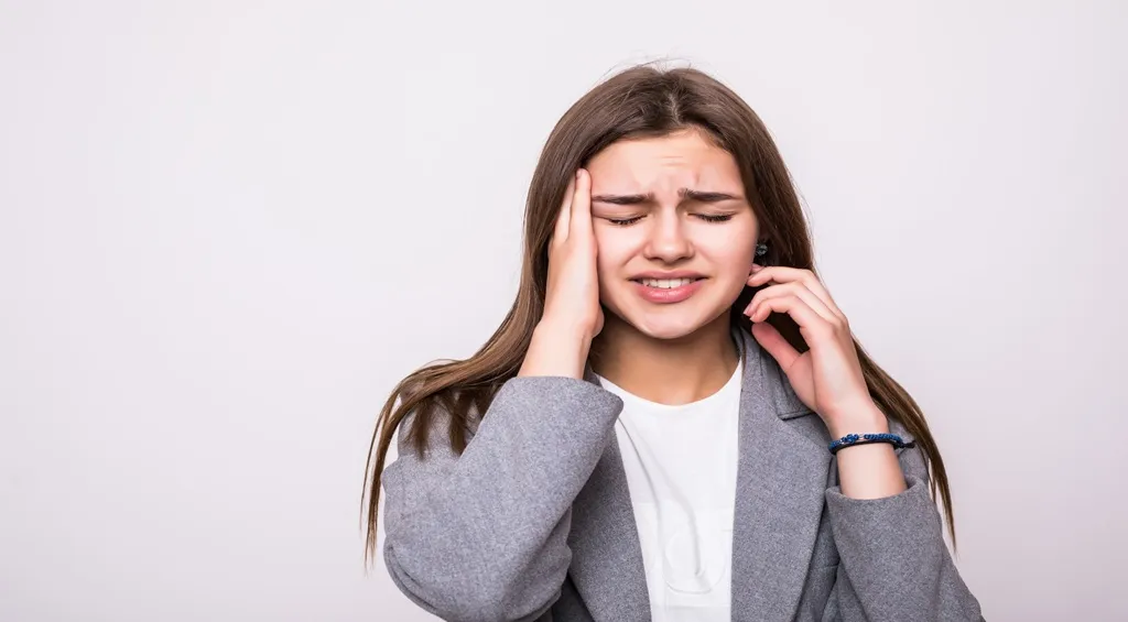 Stressed woman experiencing discomfort from wearing headphones