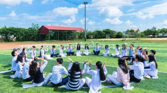 The students sat in a circle in the sun and played a game