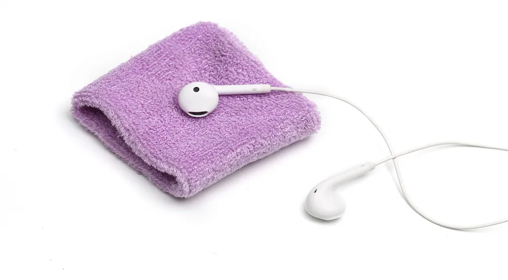 White earbuds on a towel illustrating the importance of regularly cleaning headphones