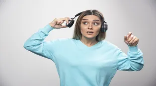 Woman removing headphones to hear people around her