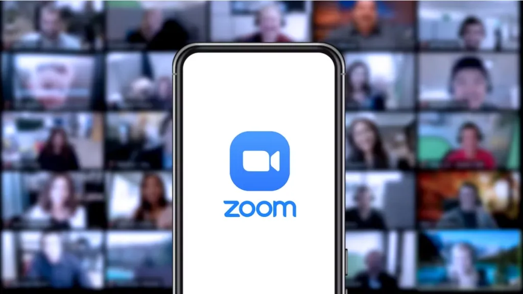 Zoom-logo-on-a-smartphone-with-a-video-call-in-the-background.avif