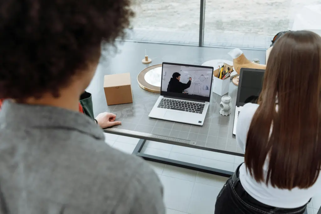 Zwei Personen fuehren ein Remote-Meeting mit Microsoft Teams Premium auf ihrem Computer durch.jpg