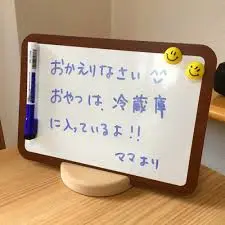 木製の机の上に卓上ホワイトボードとその他の小物が並べられている