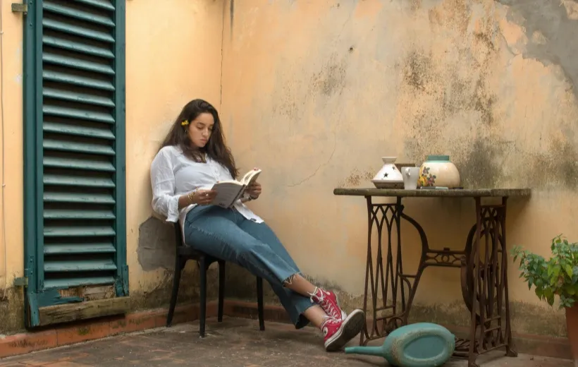 a girl reading a book in a corner