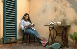 a girl reading a book in a corner