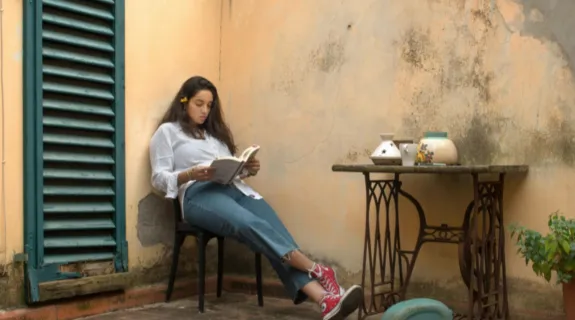 a girl reading a book in a corner