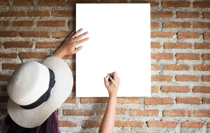 穴を開けないでホワイトボードを壁に掛けると、女の人がその上に何かを書こうとしています。