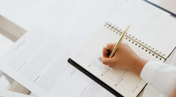 a women is writing a meeting minutes_