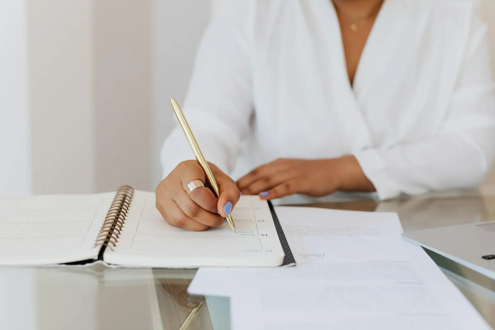 a women is writing a meeting minuts at the table.webp