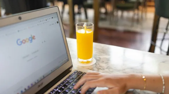 a women search something on the google with a orange juice