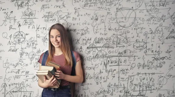 a women standing before a whiteboard which filled with lots of math formul