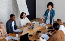 seven people are holding a meeting in the room