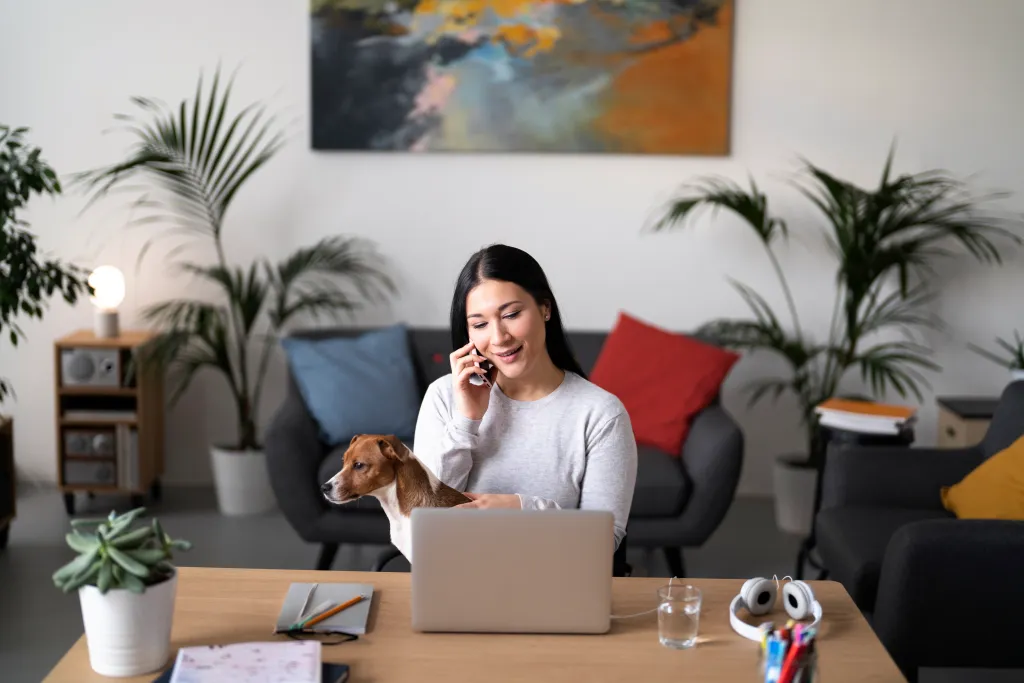 Woman using a headset for remote work while taking a call at home.