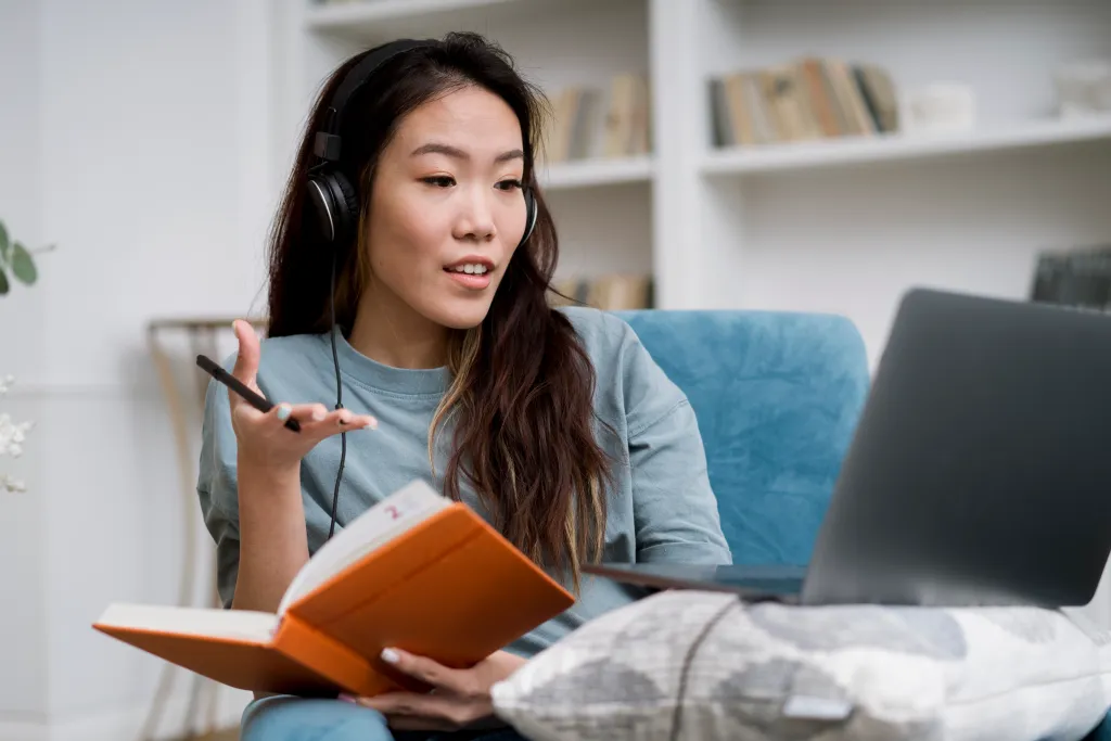Female learner practicing online language lessons with noise cancelling headphones