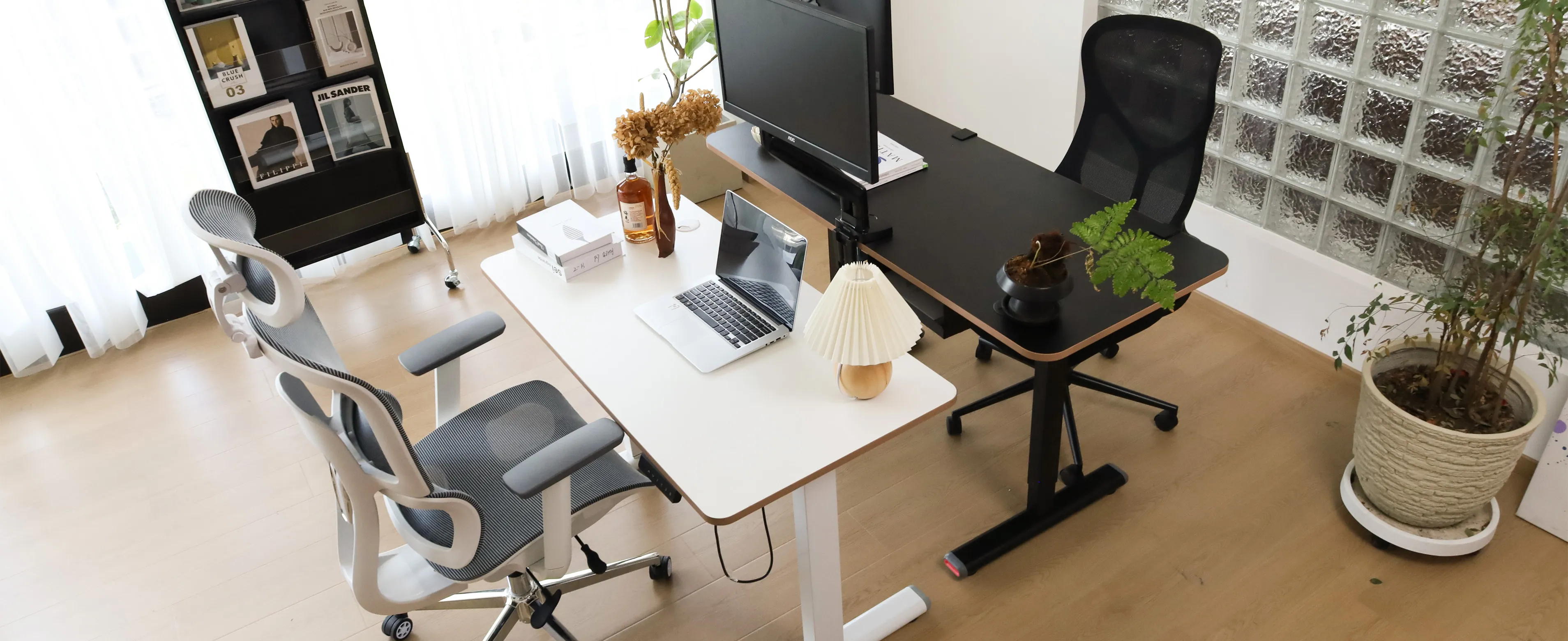 Black and white standing desk setup with ergonomic chairs in an office