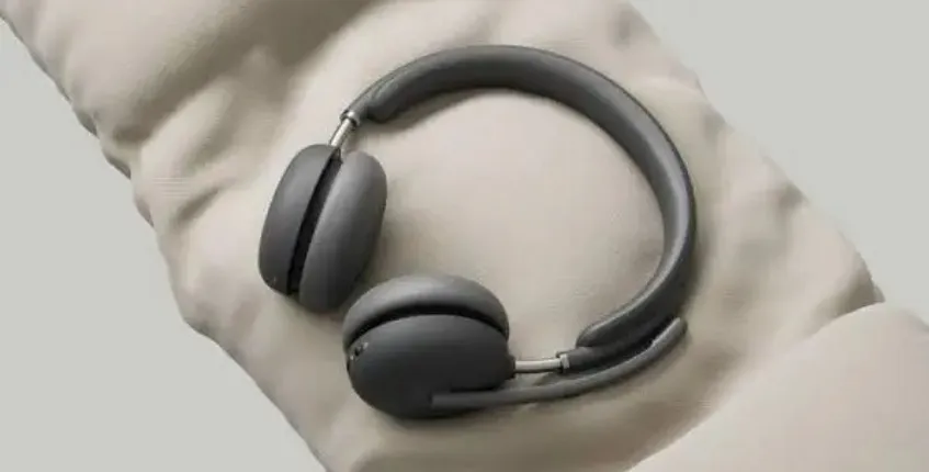 Black wireless over-ear headset with microphone resting on a soft cushion, highlighting lightweight comfort and ergonomic design.