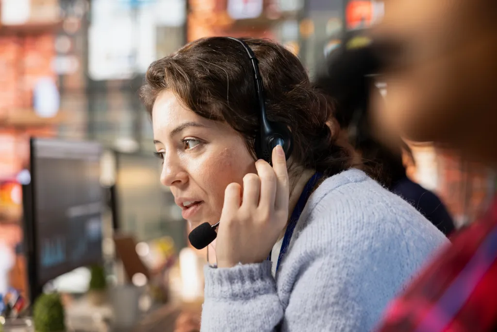 a worker is providing support using wireless earbuds for phone calls