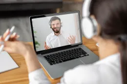 A woman wearing a headset while online meeting