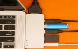 A person plugging an HDMI and a USB cable into the back of a computer to connect to a smartboard