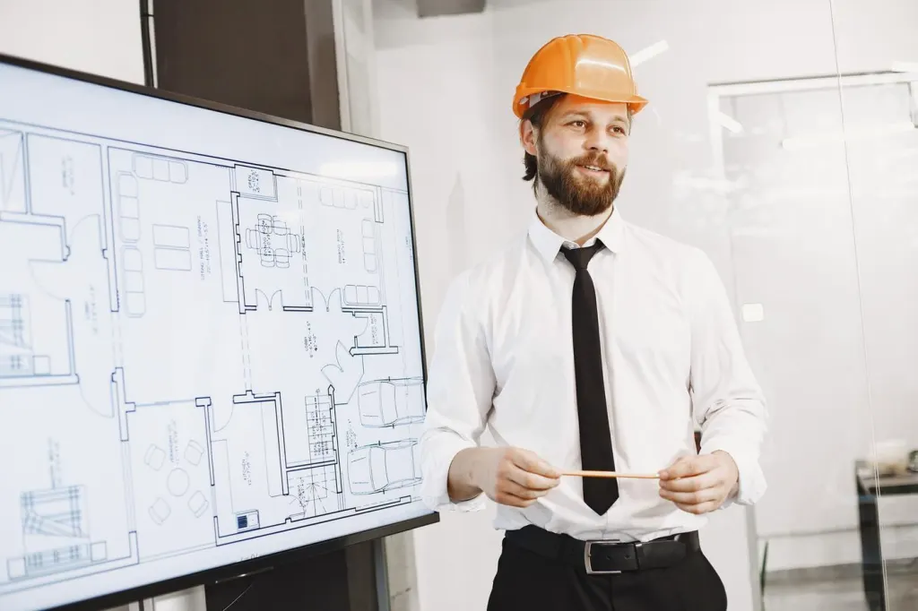 Architekt präsentiert Baupläne auf Display im Baustellen-Büro