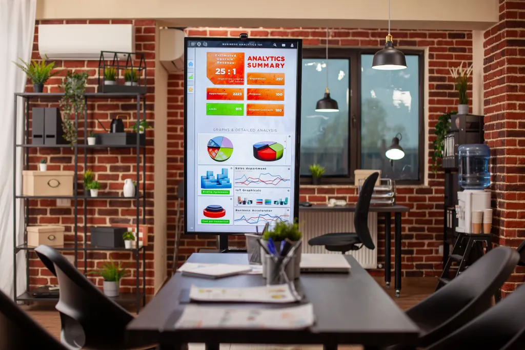 Modernes Meetingraum-Setup mit interaktivem Whiteboard für hybride Meetings mit Vor-Ort- und Remote-Teilnehmern