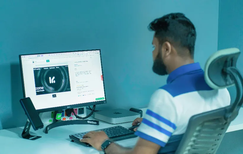 A man sit in the tall desk chair for standing desk