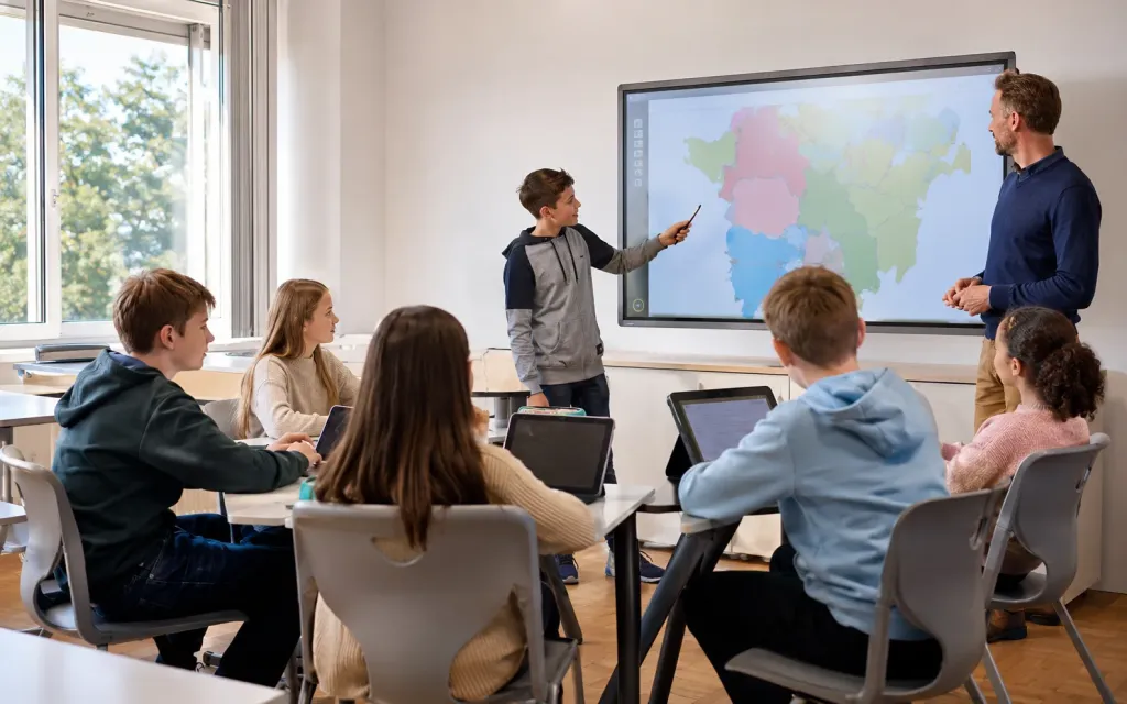 Lehrkraft begleitet kooperative Lernphasen in einem modernen Klassenzimmer
