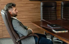 A man sits in staples hiken ergonomic chair