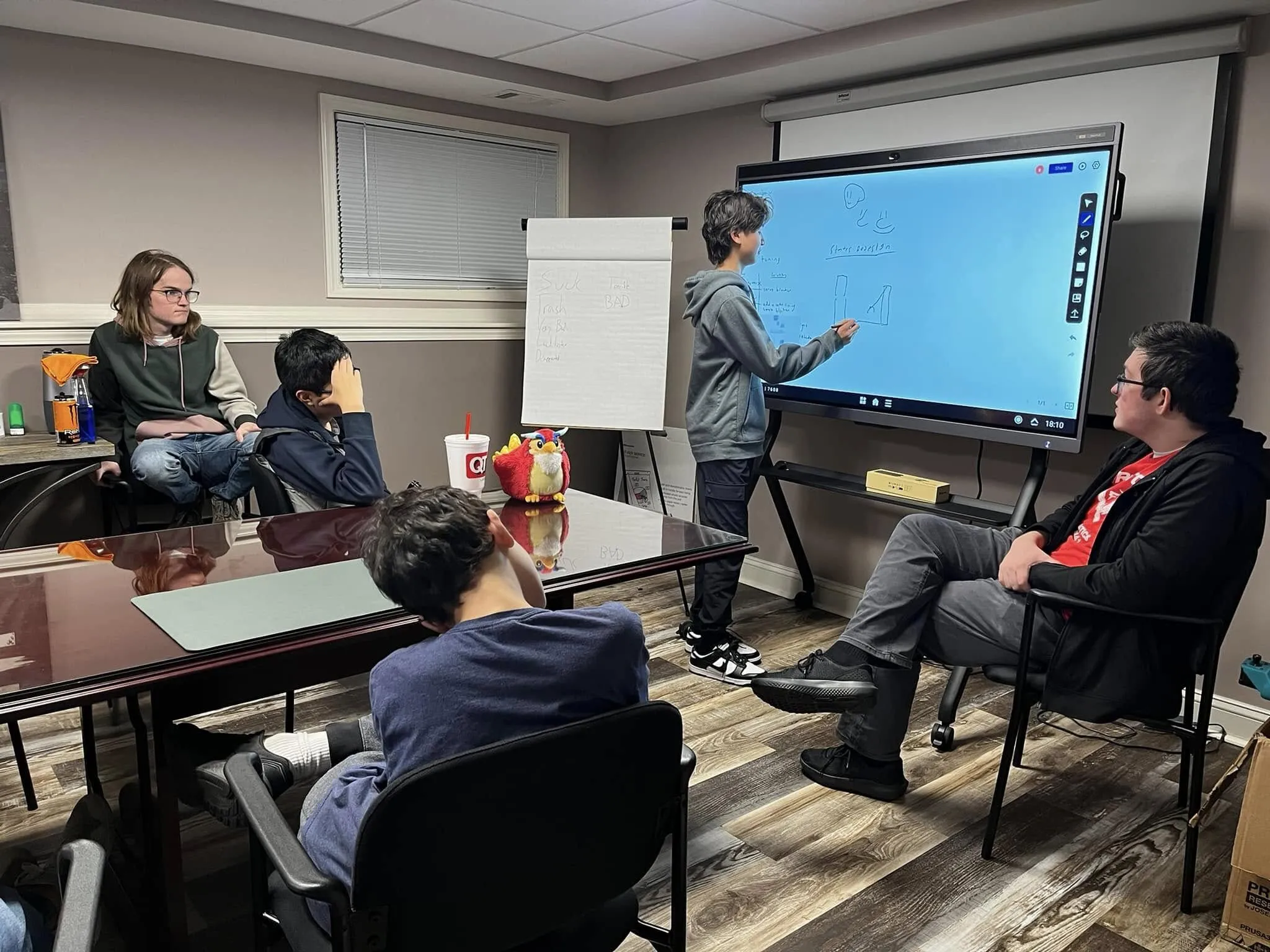 The boy uses the smart screen to write on the board