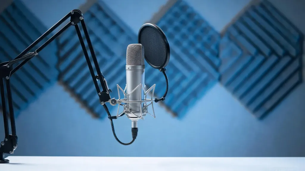 A premium desktop condenser microphone on a scissor boom arm stand with pop filter in a home studio
