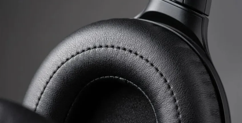 Close-up detail of soft protein leather ear cushion showing texture and stitching quality on a premium headphone earcup