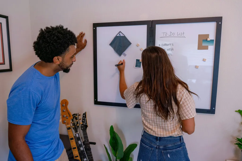 Ein mann und eine frau zeichnen auf einem smarten whiteboard