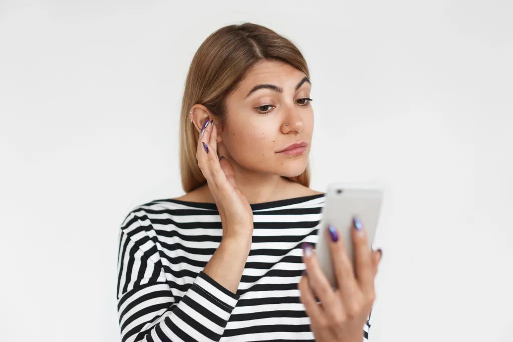 this expressive woman is thinking how to wear wireless earbuds correctly