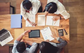4人がテーブルを囲んで「ダメな会社ほど会議が多い」というテーマについて議論している。