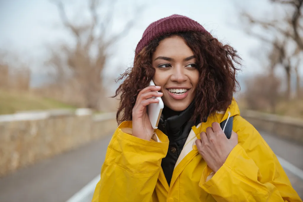 a happy lady is talking using wireless earbuds for phone calls