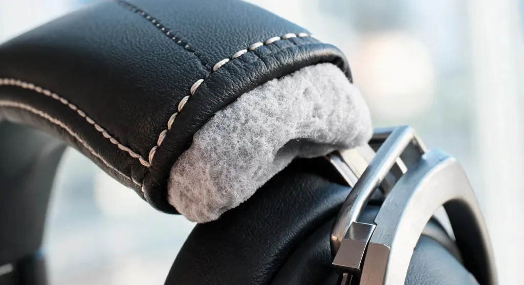 Close-up detail of premium headset ear cushions and padded leather headband showing materials and stitching