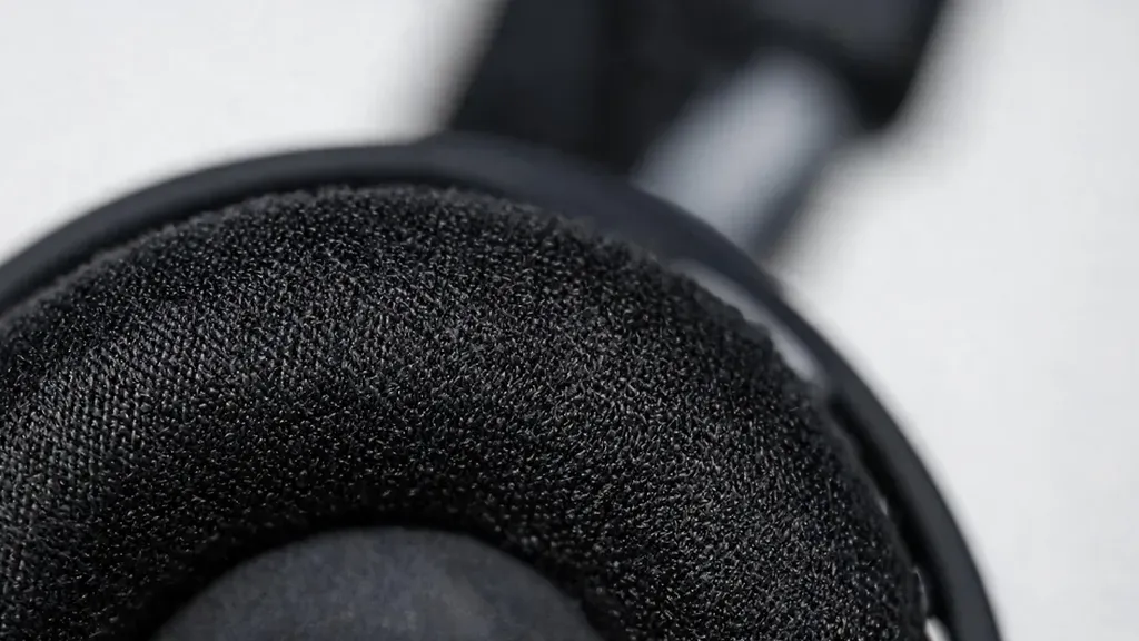 Close-up macro shot of headset ear cushion material, showing the soft foam texture and breathable fabric, shallow depth of field, product detail photography style