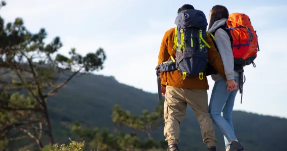 two people are hiking wearing good headphones for workout
