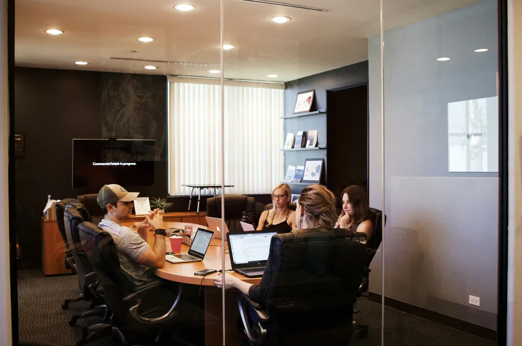 A team of professionals collaborating in a modern office using an interactive whiteboard